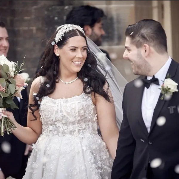 A smiling bride and groom with confetti falling around them