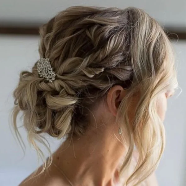 A romantic loose braided bridal updo with a hair clip